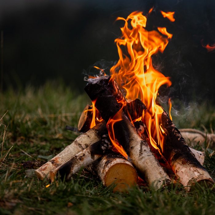Burning bonfire in the evening in the Carpathian mountains. Place for inscription.